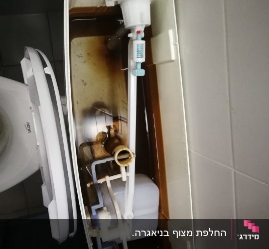 מיכל הדחה פתוח עם מנגנון פנימי חלוד